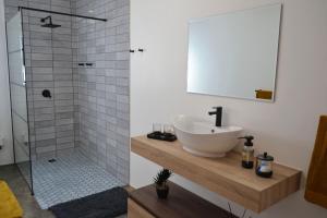 a bathroom with a sink and a shower at Mika Self Catering Cottage in Dullstroom +10 photos