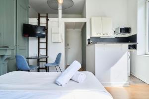 ein Zimmer mit einem Bett und zwei Stühlen und eine Küche in der Unterkunft Lille Saint Maurice - Nice and functional studio in Lille
