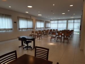 a large room with tables and chairs and windows at Matinada Palace Hotel in Paraguaçu