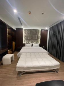 a large bedroom with two beds and a stone wall at Flamingo Ibiza Hai Tien in Thanh Hóa