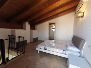 een bed in een kamer met een houten plafond bij Borgo il Castello - appartamento vista piscina e mare in Tortoreto Lido