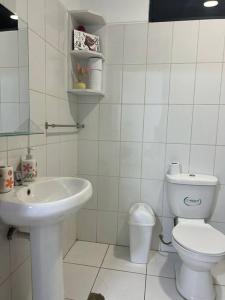 a white bathroom with a toilet and a sink at La casa de Pochita in Tarapoto