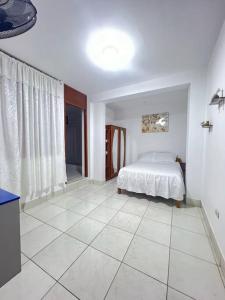 1 dormitorio con 1 cama y suelo de baldosa en La casa de Pochita, en Tarapoto