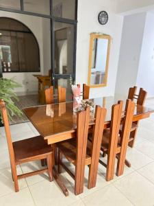 a dining room table with wooden chairs and a dining room at La casa de Pochita in Tarapoto