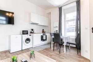 a kitchen and dining room with a table and a washing machine at Westbahnhof Kingbed 1BR Apt with ensuite washer in Vienna