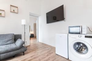 a living room with a washing machine and a couch at Westbahnhof Kingbed 1BR Apt with ensuite washer in Vienna