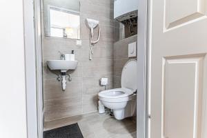 a bathroom with a toilet and a sink at Westbahnhof Kingbed 1BR Apt with ensuite washer in Vienna