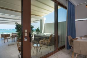 a room with a balcony with a view of the ocean at Kyma beach accommodation Delfini apartment with spa jaccuzzi 6 guests in Kolymvari