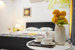 a table with two cups and a vase with flowers at Legend's studio room with Mini kitchenette in Hyderabad