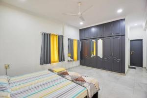 een slaapkamer met 2 bedden en een grote kast bij Legend's studio room with Mini kitchenette in Hyderabad