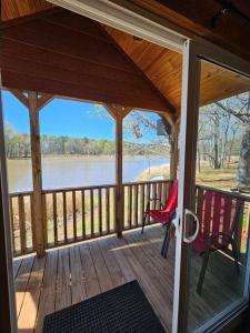 - une terrasse couverte avec 2 chaises et une vue sur le lac dans l'établissement Wheeler Lake Sunset Retreat 1, à Hillsboro