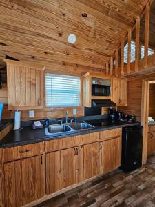 - une cuisine avec des placards en bois et un évier dans une cabine dans l'établissement Wheeler Lake Sunset Retreat 1, à Hillsboro