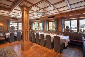 a restaurant with tables and chairs in a room at Hotel Krallerhof in Leogang