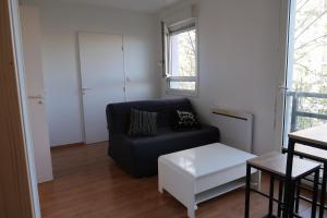 a living room with a black couch and a window at Appartement avec vue sur le lez in Montpellier