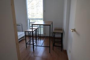 - deux tables et deux tabourets dans une chambre avec fenêtre dans l'établissement Appartement avec vue sur le lez, à Montpellier