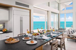 a dining room with a table with food on it at La Mer South, Luxury Oceanfront on Sapodilla Bay in Providenciales