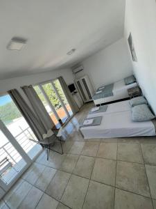 een slaapkamer met een bed en een groot raam bij IN Villa Guesthouse in Sutomore