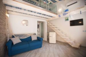 ein Wohnzimmer mit einem blauen Sofa und einer Treppe in der Unterkunft La Casetta nel Porto in Castellammare del Golfo
