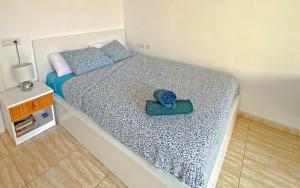 ein kleines Schlafzimmer mit einem Bett mit einer blauen Decke in der Unterkunft Estudio para dos en Martianez in Puerto de la Cruz