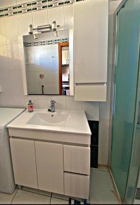 ein weißes Badezimmer mit einem Waschbecken und einem Spiegel in der Unterkunft Estudio para dos en Martianez in Puerto de la Cruz