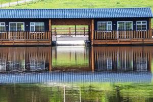 Waterfront Lodges - South Cabin في بالينامور: منزل على رصيف على هيئة ماء