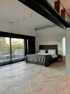 Remarkable 7-Bed House in London في لندن: غرفة نوم بسرير كبير وبلكونة
