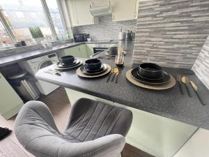 uma cozinha com um balcão com pratos e uma cadeira em Okapi peace of paradise em Leeds