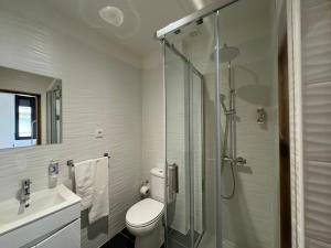 ein Bad mit einer Dusche, einem WC und einem Waschbecken in der Unterkunft Casas da Corujeira 2 in Porto