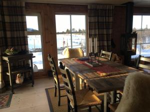 jadalnia z drewnianym stołem i krzesłami w obiekcie New and cozy family cabin on Golsfjellet w mieście Golsfjellet
