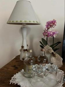 een tafel met twee flessen en een lamp en bloemen bij B&B Il Gufo in Erto