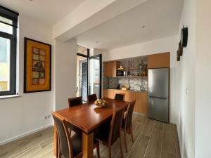 uma cozinha com uma mesa de madeira e um frigorífico em Casas da Corujeira 2 em Porto