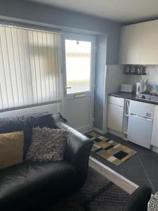 a living room with a couch and a kitchen at Ground Floor Hillview 2 bedroom Apartment in Brean