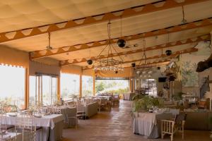 un salón de banquetes con mesas y sillas blancas en Hacienda El Rosalejo, en Villamartín