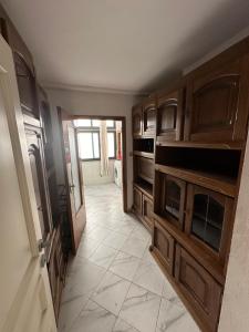 a kitchen with wooden cabinets and a tile floor at You will love it in Durrës