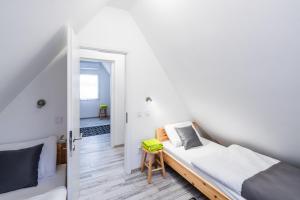 1 dormitorio con 1 cama y puerta que conduce a un pasillo en Alborella Vendégház, en Fadd