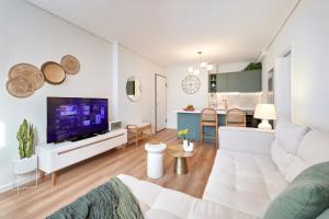 ein Wohnzimmer mit einem Sofa und einem TV in der Unterkunft Athens Premium Suites - Sunny 2 Bedroom Suite with Parking in Athen