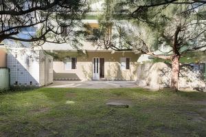 a white house with a tree in front of it at Apartlaguna in Laguna