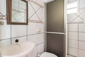 a bathroom with a sink and a toilet and a mirror at Apartlaguna - 2 residenciais diferentes in Laguna +101 photos