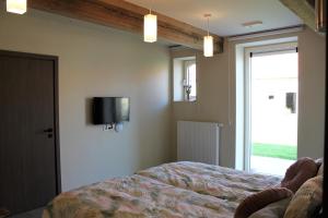 een slaapkamer met een bed en een tv aan de muur bij Bibi's Boerderij in Veurne