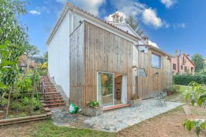 a house with wooden siding and a patio at Bacom House completa in Caldes de Malavella