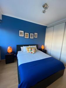 a blue bedroom with a large bed with two lamps at Columbano's House - Apartment in Central Lisbon in Lisbon