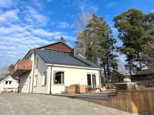 une petite maison blanche avec un toit noir dans l'établissement Luxury Villa with Jacuzzi, à Stockholm
