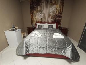 1 dormitorio con 1 cama grande y toallas. en Red Fox Rooms, en Decimomannu