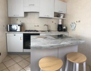 ストレーザにあるLa Terrazza degli Oleandriのキッチン(大理石のカウンタートップ、スツール2脚付)