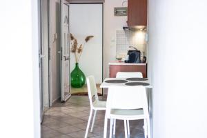 a kitchen with a table and white chairs at Daphne's studio 2 in Skiathos