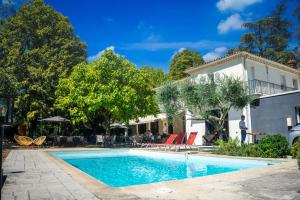 a swimming pool in front of a house at La Redoniere in Romans-sur-Isère