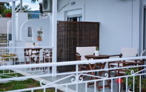 a balcony with chairs and tables on a house at Daphne's studio 2 in Skiathos Town