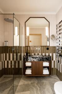 uma casa de banho com um chuveiro, um lavatório e um espelho. em Zinar Castle em Cracóvia