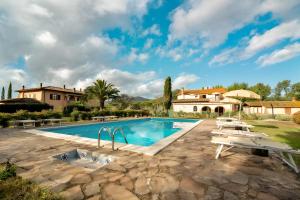 a swimming pool in front of a house at Agriturismo Casetta in Gavorrano