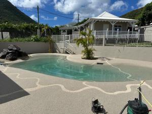a small swimming pool in front of a house at Résidence La Palmeraie in Le Diamant